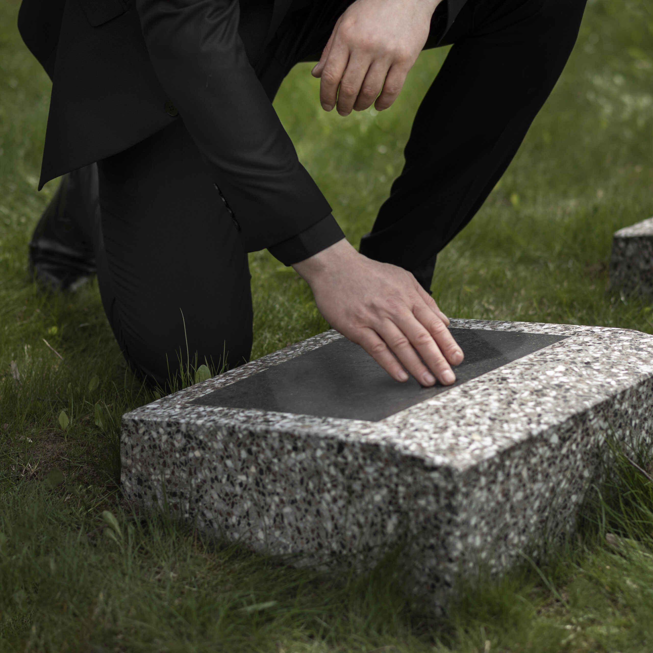 man-visiting-gravestone-cemetery